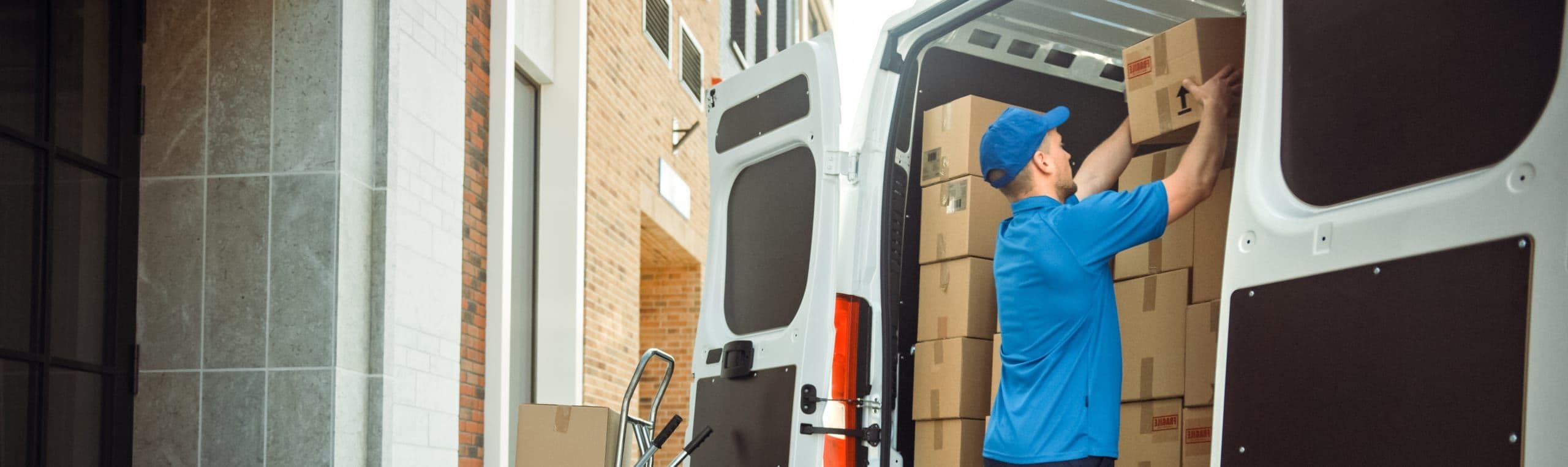 Courier loading parcels in van